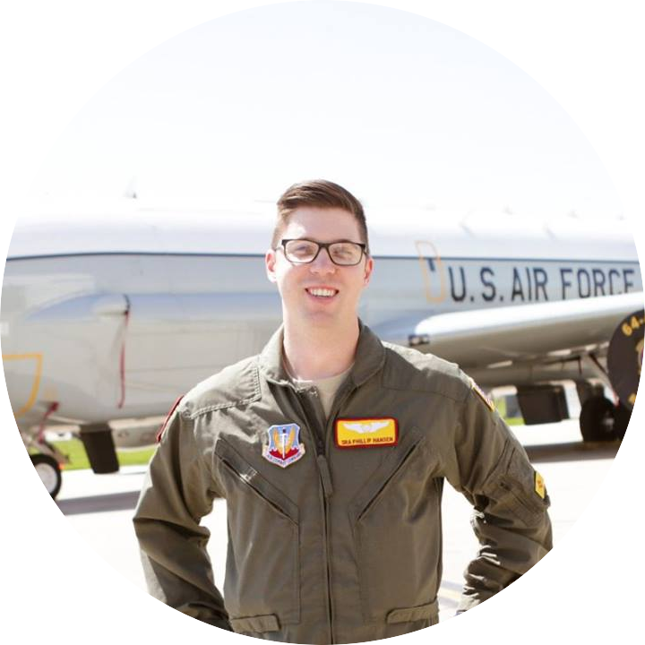 The website owner in a green Air Force flight suit standing in front of a military aircraft.
